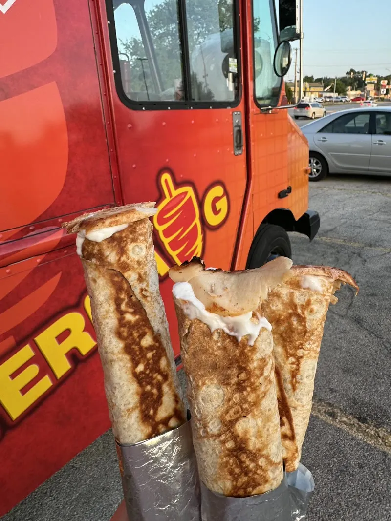 Two shawerma wraps crossed with fries, steam rising off the paper